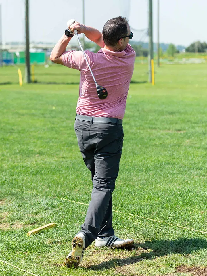 A boy finishes his swing on the Market Sports driving range.