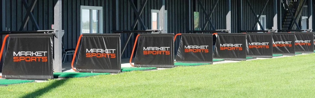 The Market Sports driving range with tee mats and target flags.