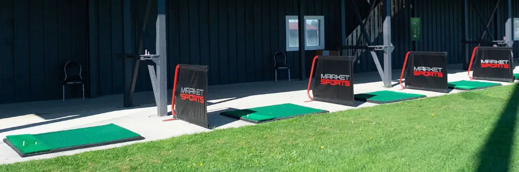 Panoramic view of the lower-level covered driving range tees at Market Sports.