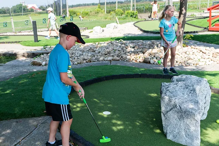Three boys play mini putt at Market Sports.